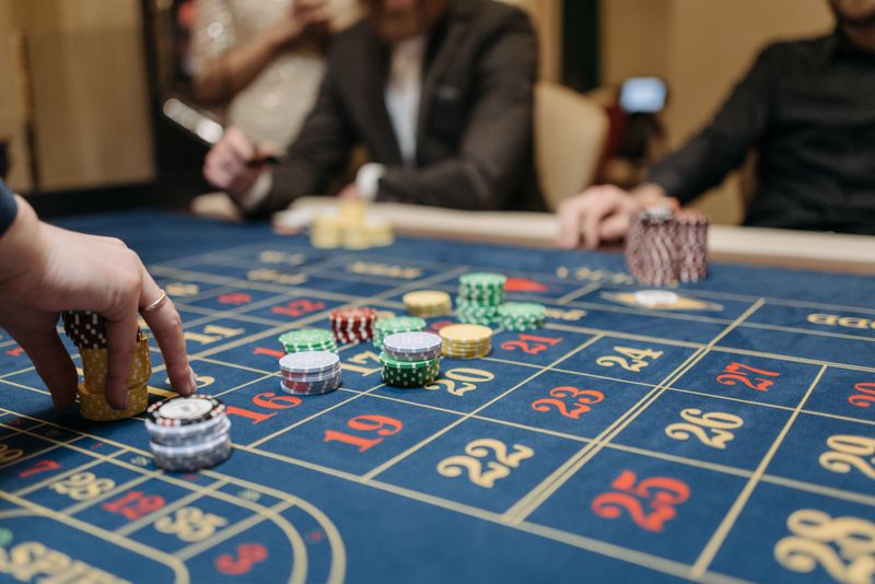 Tangan pemain menaruh chip di meja roulette