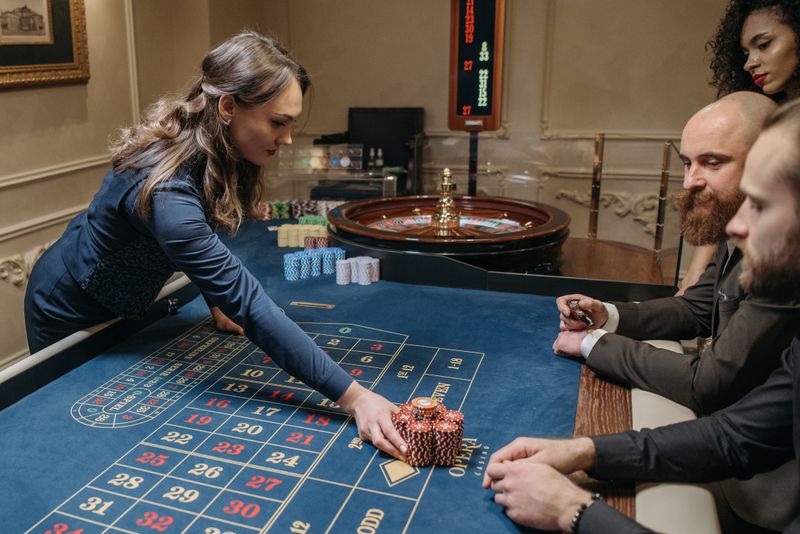 Dealer dan pemain di meja roulette dalam suasana tenang